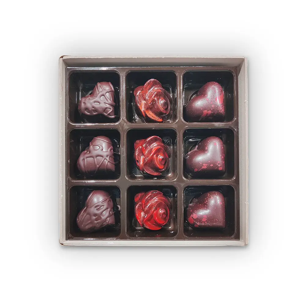 Caja con 9 bombones, con formas de corazón y rosa.